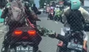 TEKS: Video menunjukan seorang pria berseragam TNI melakukan aksi tendang motor seorang ibu yang sedang bonceng anaknya.(Ist)