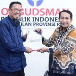 TEKS: Bupati Bengkalis diwakili Asisten Administrasi Umum Aulia serahkan Laporan Kepatuhan Standar Pelayanan Publik Pemerintah Kabupaten Bengkalis tahun 2023 kepada Kepala Perwakilan Ombusman RI Provinsi Riau Bambang Pratama.(Foto:informasiterpercaya.com)